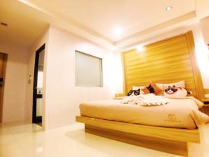 a bedroom with a large bed with a wooden headboard at Cat Story Hotel in Patong Beach