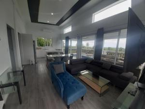 ein Wohnzimmer mit einem blauen Sofa und einem Tisch in der Unterkunft Mai'i Villa 1 - Muri in Avarua