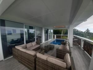 a living room with couches and a swimming pool at Mai'i Villa 1 - Muri in Avarua