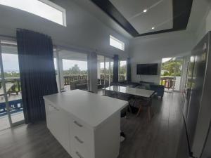 eine Küche und ein Wohnzimmer mit einem Tisch und einem Schreibtisch in der Unterkunft Mai'i Villa 1 - Muri in Avarua