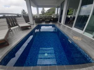 a swimming pool with blue tiles on a house at Mai'i Villa 1 - Muri in Avarua