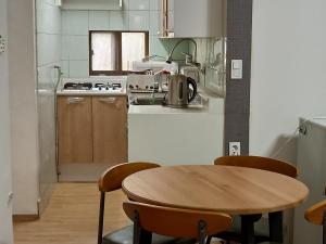 a kitchen with a wooden table and chairs in a kitchen at Jemulpo house - Foreigner Only in Incheon