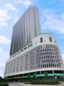 un edificio blanco alto con muchas ventanas en M Hotel Singapore City Centre en Singapur