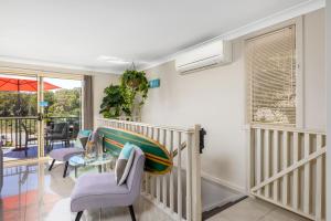 a living room with a table and chairs at Aqua Lagoon - Great Family Beach Getaway in Nelson Bay