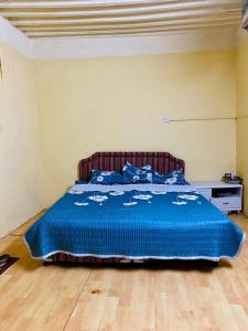 a bedroom with a bed with a blue comforter at Sehma Guest House in Al Ḩamrāʼ