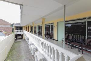 a balcony of a building with chairs and tables at RedDoorz at CBR Residence Blimbing in Malang