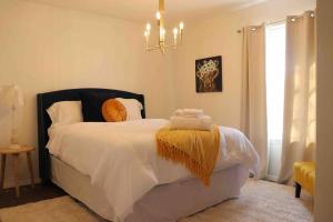 um quarto com uma cama com lençóis brancos e almofadas laranja em By HWY, 3/2 , sleeps large group Palo Duro Fun em Amarillo