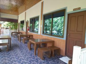 a row of tables and benches next to a building at Pechpailin Resort in Kanchanaburi City