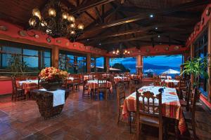 ein Restaurant mit Tischen, Stühlen und einem Kronleuchter in der Unterkunft Hotel Atitlan in Panajachel