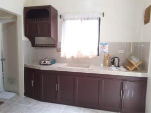 a kitchen with a sink and a window at Tresha Lance Apartelle in Boracay