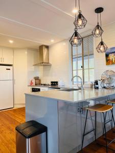 una cocina con un gran mostrador blanco con fregadero en Katoomba Hideaway - Blue Mountains Modern Getaway, en Katoomba