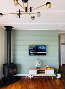 sala de estar con chimenea y fogones en Katoomba Hideaway - Blue Mountains Modern Getaway, en Katoomba