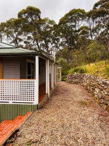 una casa en un camino de grava junto a una pared de piedra en Katoomba Hideaway - Blue Mountains Modern Getaway, en Katoomba