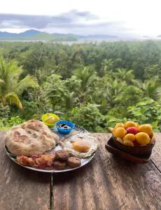 a plate of food sitting on a table with fruit at Jungle bar Resto & Cottages in Port Barton