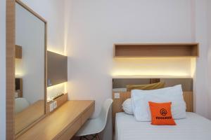 - une chambre d'hôtel avec un lit et un miroir dans l'établissement KoolKost Syariah near Taman Sriwedari Laweyan, à Solo