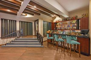 a bar at a hotel with blue chairs at Sterling Yercaud in Yercaud