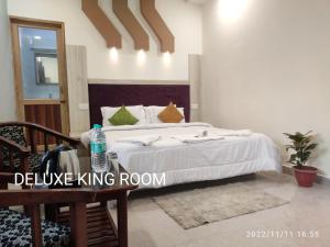 a bedroom with a bed and a table with a water bottle on it at Max Guest House in Agra