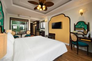 Schlafzimmer mit einem großen weißen Bett und einem Schreibtisch in der Unterkunft La Passion Hanoi Hotel & Apartment in Hanoi