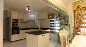 una cocina con armarios blancos y fregadero. en Kawruky Hotel Guobadia, en Benin City