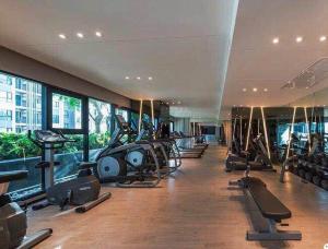 un gimnasio con filas de cintas de correr y máquinas elípticas en 泰国芭提雅thebase无边游泳池公寓, en Pattaya central