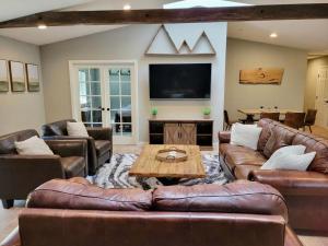 a living room with leather furniture and a flat screen tv at Sky Lodge in Wrightwood