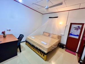 1 dormitorio con 1 cama con mosquitera en Mangrove Bay Inn, en Weligama