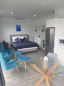 アバルアにあるMai'i Villa 2 - Muriのベッドルーム1室(ベッド1台、青い椅子、テーブル付)