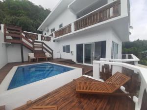 a house with a swimming pool and a deck at Mai'i Villa 2 - Muri in Avarua