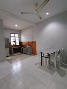 a room with a table and chairs and a kitchen at Promenade Homestay 2 in Kampong Sura Masjid