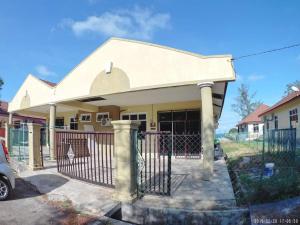 ein Haus mit einem Tor davor in der Unterkunft Promenade Homestay 2 in Kampong Sura Masjid