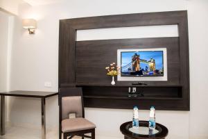 a living room with a television on a wall at Hotel Platinum Shravasti in Katra