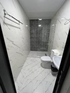 y baño blanco con aseo y ducha. en HAZINIY HOTEL, en Tashkent