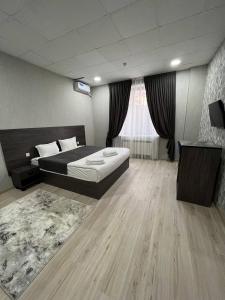 1 dormitorio con 1 cama y TV en HAZINIY HOTEL, en Tashkent