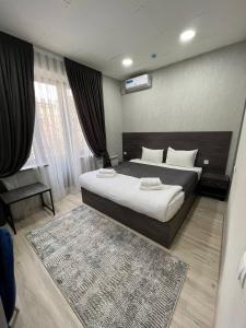 1 dormitorio con 1 cama grande y 1 alfombra en HAZINIY HOTEL, en Tashkent