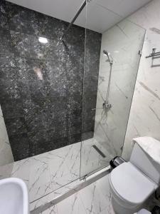 y baño con ducha, aseo y lavamanos. en HAZINIY HOTEL, en Tashkent