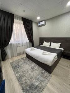 1 dormitorio con 1 cama grande y 1 alfombra en HAZINIY HOTEL, en Tashkent