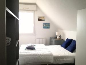 a bedroom with two beds with blue pillows and a window at Appartement Étel, 3 pièces, 5 personnes - FR-1-479-71 in Étel
