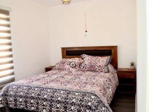 埃爾塔波的住宿－Hermosa Casa El Tabo nueva en condominio，一间卧室配有一张带被子和枕头的床