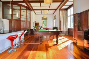 a large room with a pool table and some chairs at The Gisborne Club - Boutique accommodation in Gisborne