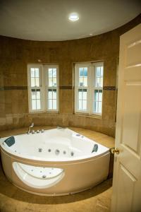 een groot wit bad in een kamer met ramen bij Villa Sweet Villa - Montego Bay in Montego Bay