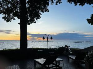 a bench and a table with a laptop in front of the ocean at Sky Beach Pattaya in North Pattaya