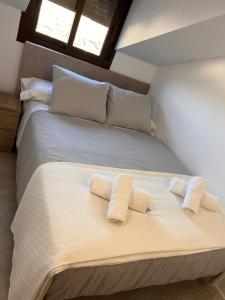 1 cama blanca grande con 2 almohadas en ATICO BUENAVISTA, en Ardales