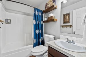 a bathroom with a white toilet and a sink at Southwestern Style 4 Bedroom Nampa Home Sleeps 16! in Nampa +21 photos