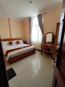 ein Schlafzimmer mit einem Bett, einem Stuhl und einem Fenster in der Unterkunft Kim Huong Quang Hotel in Phu Quoc
