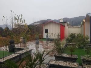 a view of a garden with a small building at Hotel Roof Cottages Swat in Swat