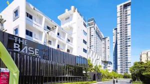 a tall white building with a sign that reads the base at 泰国芭提雅无边游泳池精装修公寓临近大海两卧室 in Pattaya Central