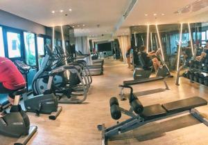 a gym with rows of treadmills and people working out at 泰国芭提雅无边游泳池精装修公寓临近大海两卧室 in Pattaya Central