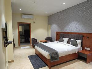 ディブルガルにあるHOTEL GOLDEN ORCHIDのベッドルーム(大型ベッド1台付)、リビングルームが備わります。
