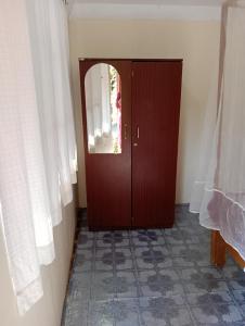 a wooden door with a window in a room at Namaste Beach Huts in Patnem