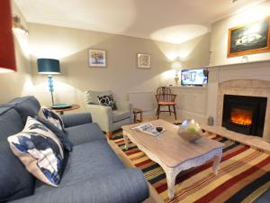ein Wohnzimmer mit einem blauen Sofa und einem Kamin in der Unterkunft Crabbe Corner in Aldeburgh